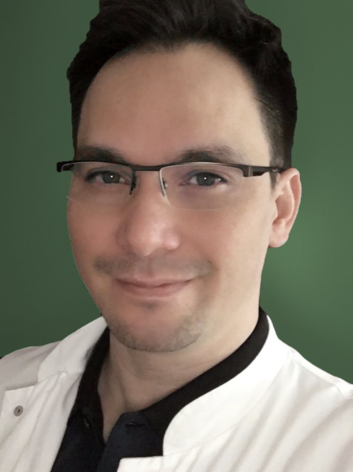 Porträt von Dr. Sebastian Warncke im weißen Arztkittel